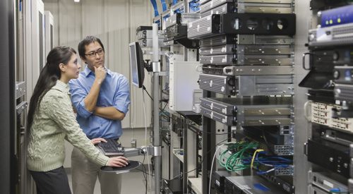 Multi-ethnic coworkers working in computer server room